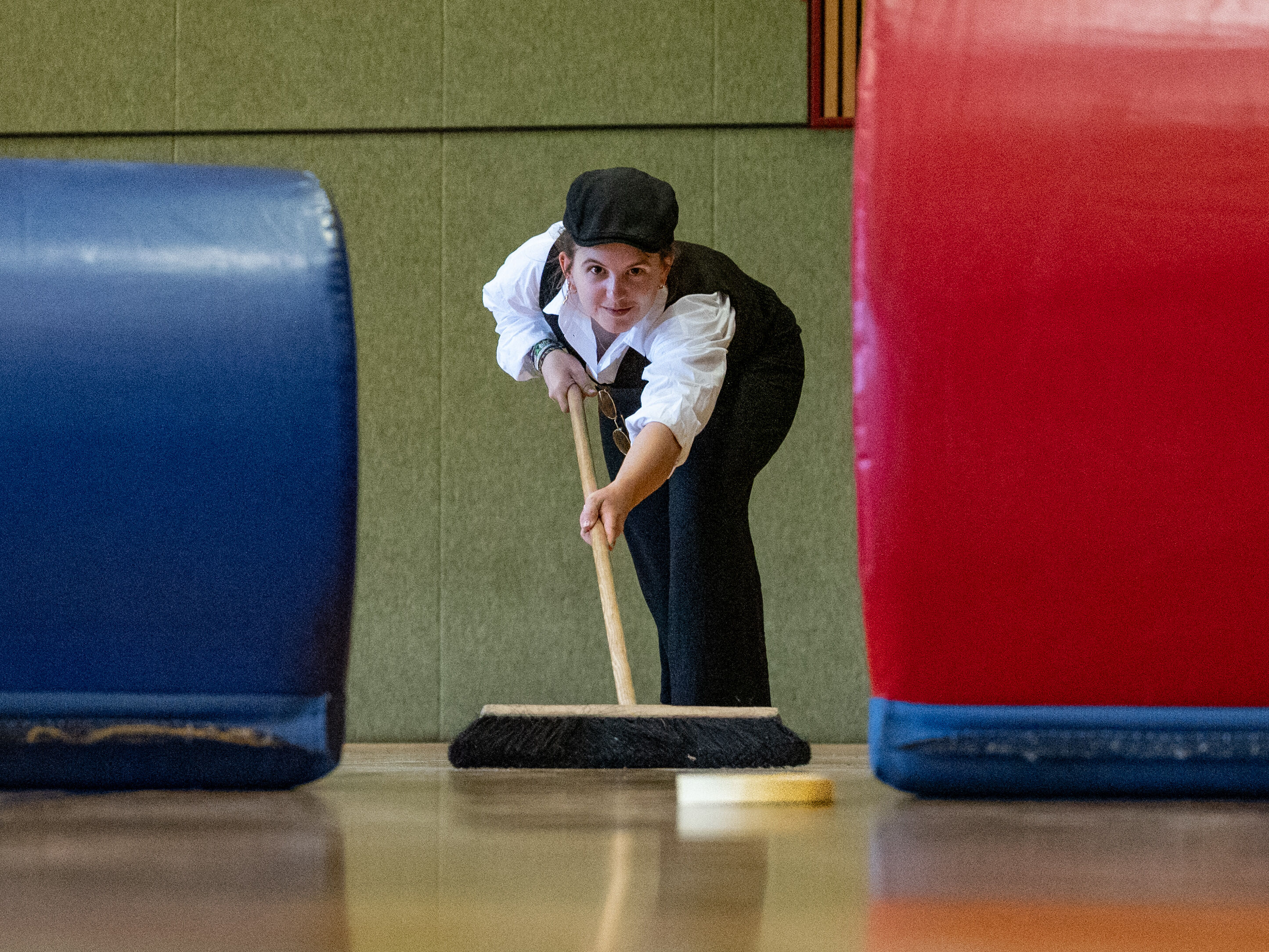 Person carefully pushing a Quibble with a Broom through a gap between two obstacles