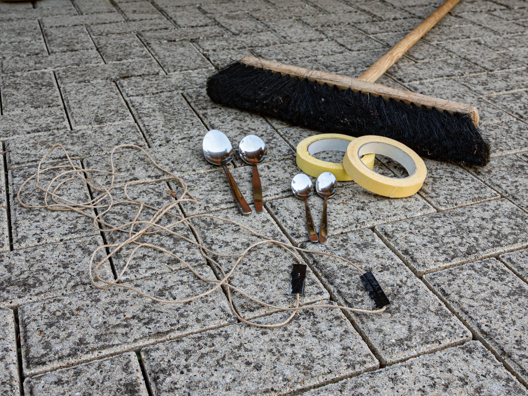 A Bakewell Broom, two Quibbles, two Somerset Spoons, two Baroness Shackleton Spoons and two Slingshots lay on cobblestone pavement.
