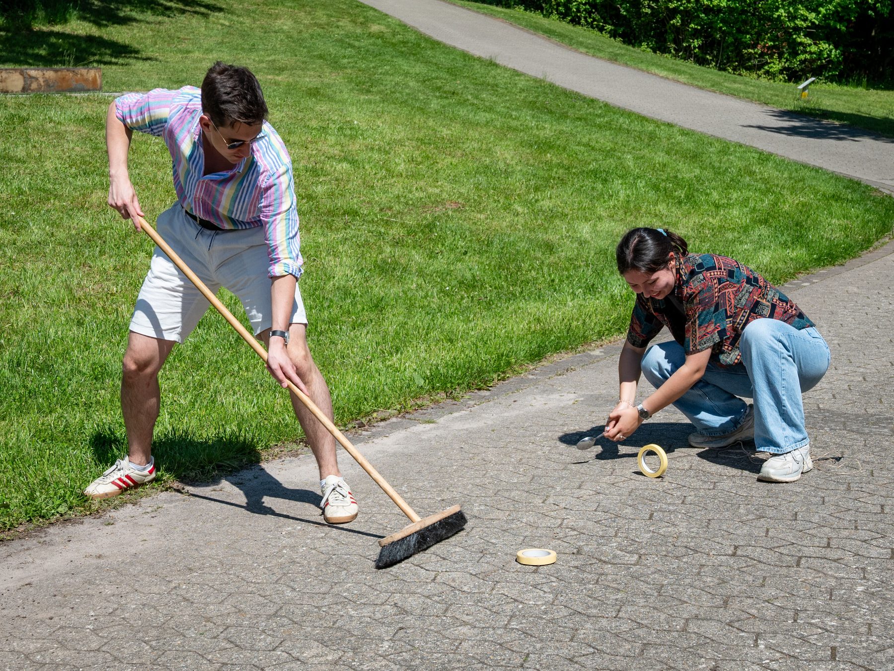 Two people doing their first shots with a Broom and a Spoon