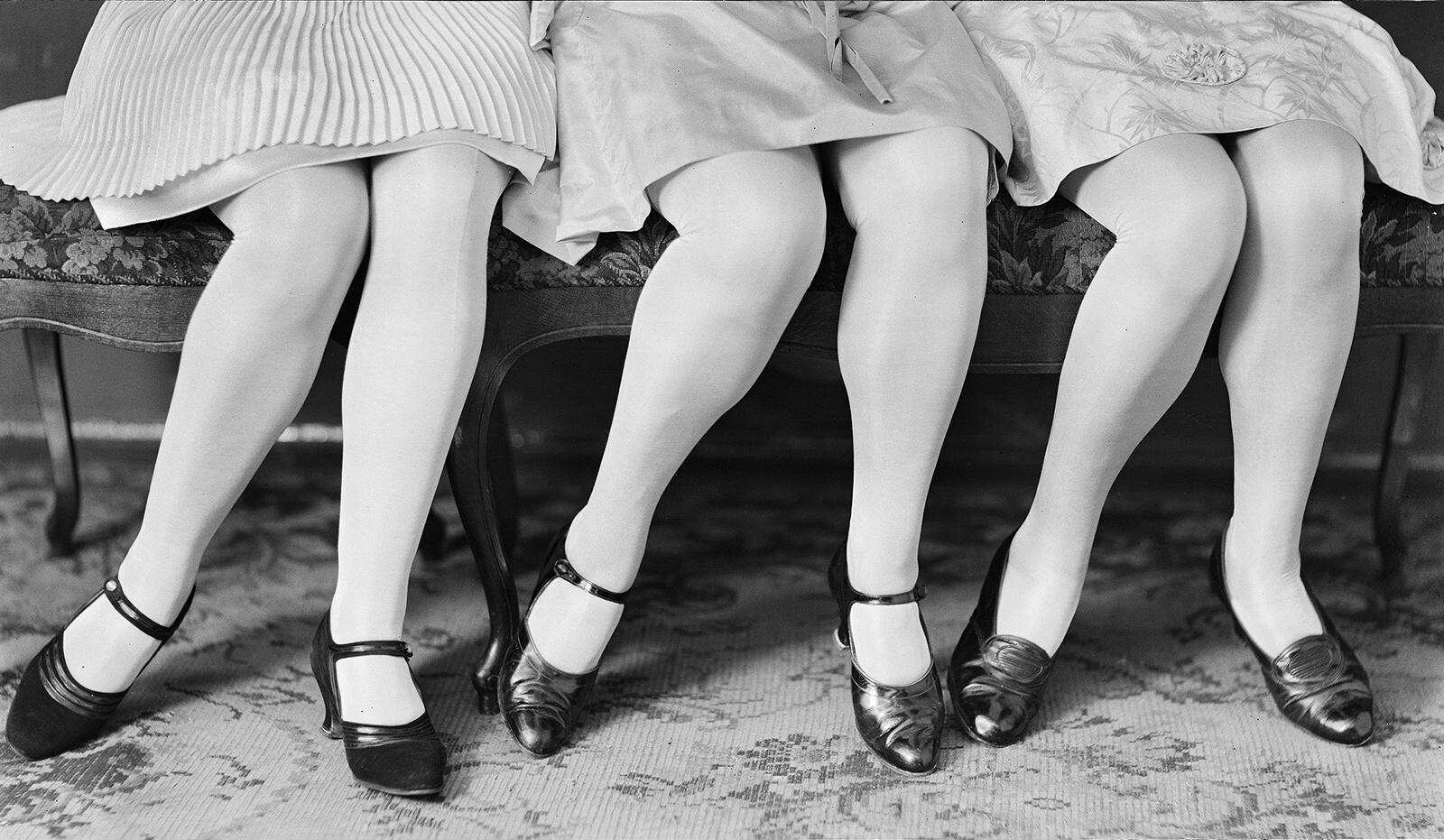 Black-and-white photograph of three women showing their new nylon tights